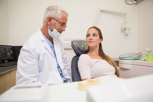 Dentist and patient looking at each other at the dental clinic
