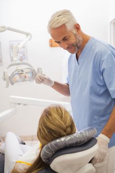 Dentist smiling at patient in the chair at the dental clinic