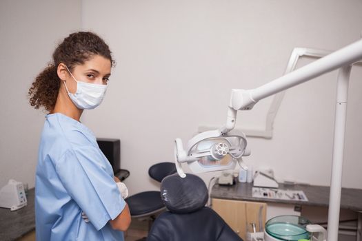 Dentist in surgical mask looking at camera at the dental clinic