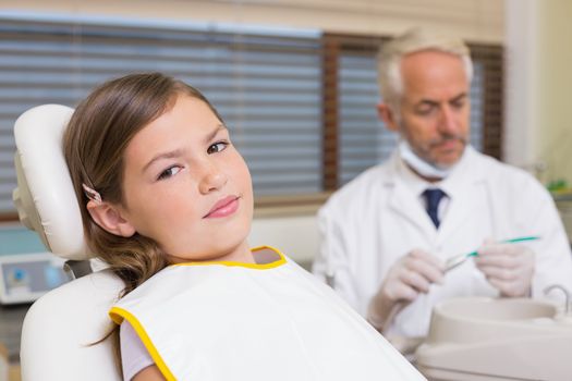 Little girl sitting in dentists chair at the dental clinic