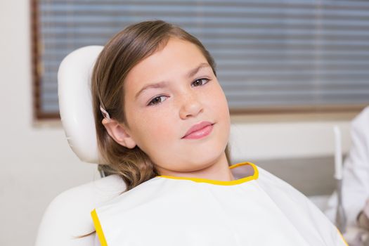 Little girl sitting in dentists chair at the dental clinic