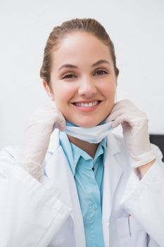 Dentist putting on her surgical mask at the dental clinic