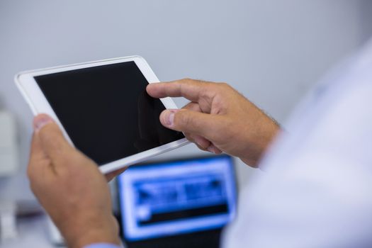 Dentist using digital tablet in clinic