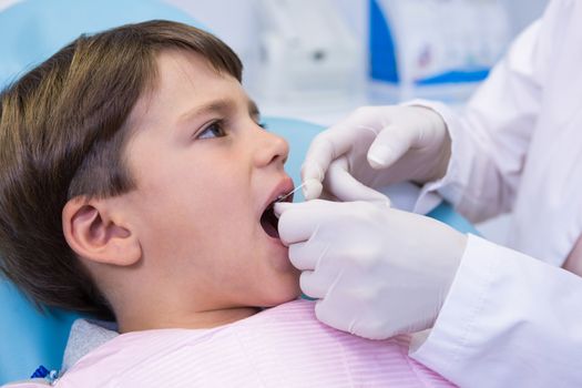 Boy receiving dental treatment by dentist at medical office