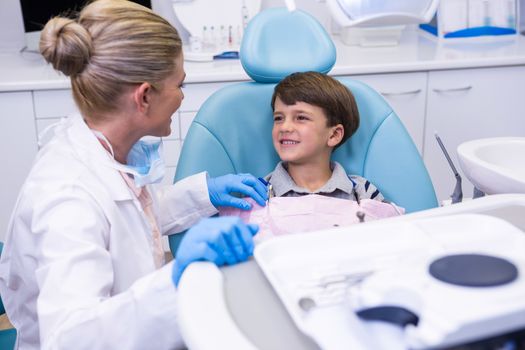 Side view of dentist talking with boy at medical clinic