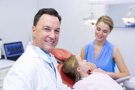 Portrait of dentist smiling at camera in dental clinic