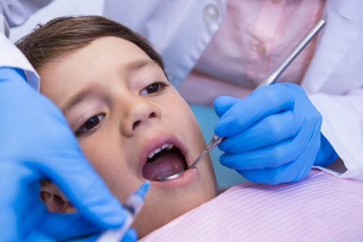 Cropped image of dentist examining boy at medical clinic