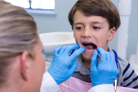 Close up of dentist examining boy at dental clinic