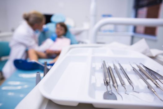 Close up of medical equipment on tray by dentist examining boy at medical clinic