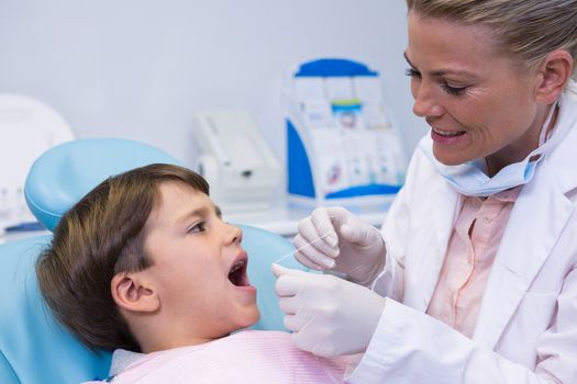 Happy dentist examining boy at medical clinic