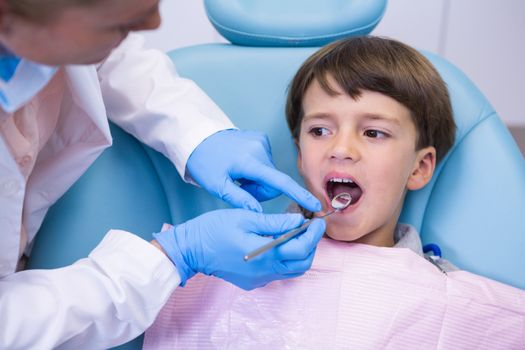 Close up of dentist examining boy at medical clinic
