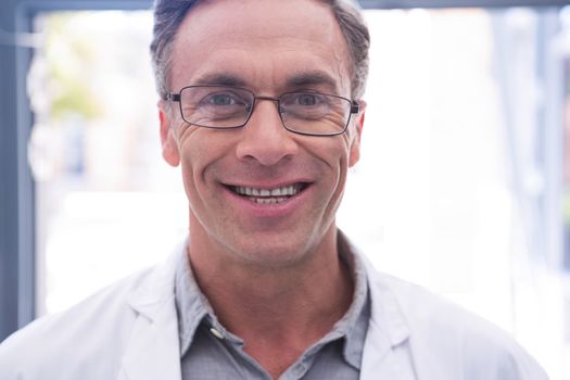 Portrait of smiling dentist with eyeglasses at clinic