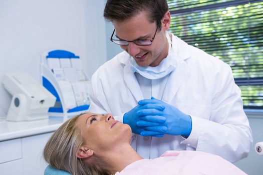 Smiling dentist looking at patient in medical clinic