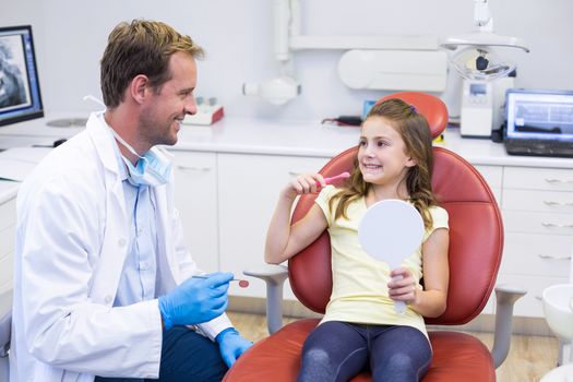 Smiling young patient interacting with dentist in dental clinic