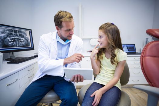 Young patient showing teeth to dentist in dental clinic