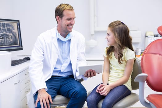Smiling dentist interacting with young patient in dental clinic