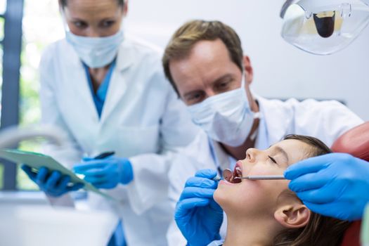 Dentist examining a young patient with tools in dental clinic