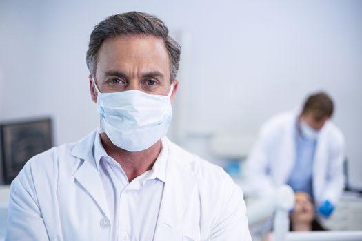 Portrait of confident dentist in surgical mask at dental clinic