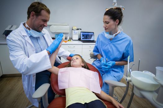 Dentist giving high five to young patient I dental clinic
