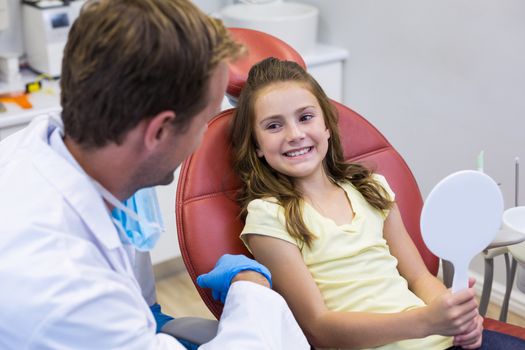 Smiling young patient interacting with dentist in dental clinic