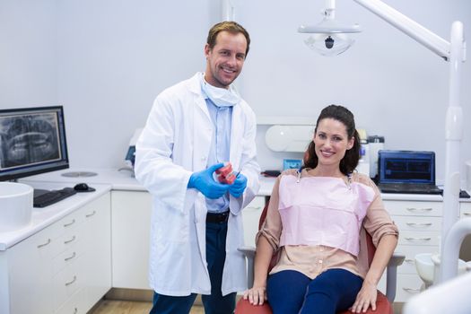 Portrait of smiling dentists and female patient at dentist clinic