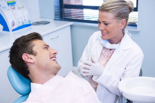 Happy man disscussing with dentist at medical clinic