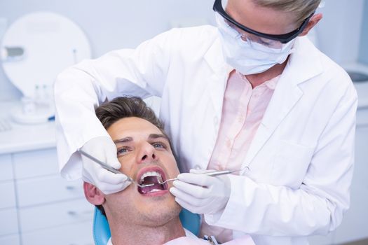 Close up of dentist examining man mouth at medical clinic