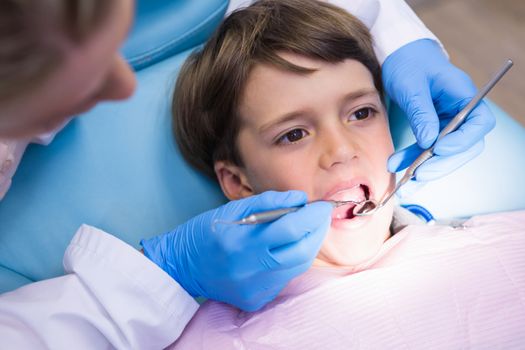 High angle view of dentist examining boy at medical clinic