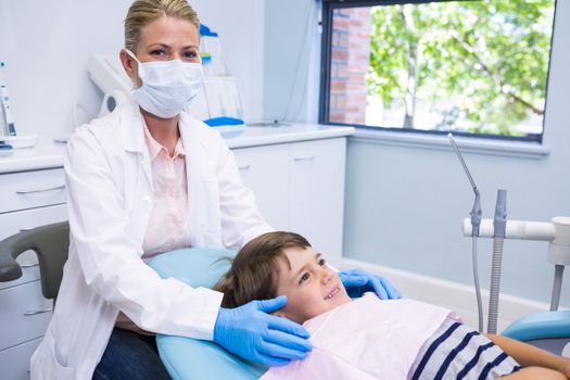Portrait of dentist standing by boy at dental clinic