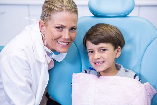 Portrait of smiling dentist and boy at dental clinic