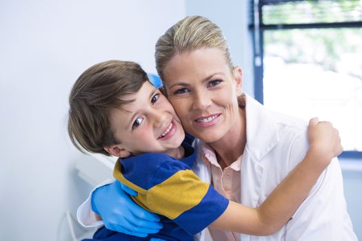 Portrait of smiling dentist with boy at medical clinic