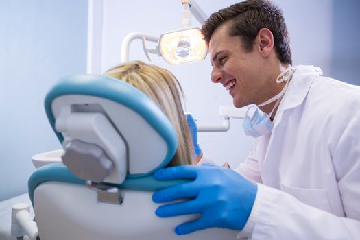 Happy dentist examining woman at medical clinic