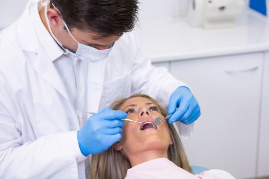 Close up of dentist examining woman at dental clinic