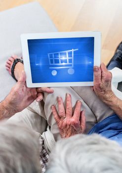 Digital composite of Old People using Tablet with Shopping trolley icon
