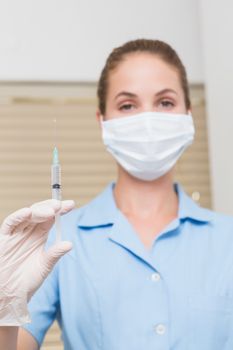 Dental assistant holding injection looking at camera at the dental clinic