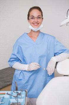 Dentist in blue scrubs smiling at camera at the dental clinic