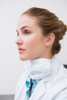 Dentist with surgical mask thinking at the dental clinic
