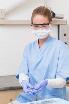 Dentist in blue scrubs holding dental tools at the dental clinic