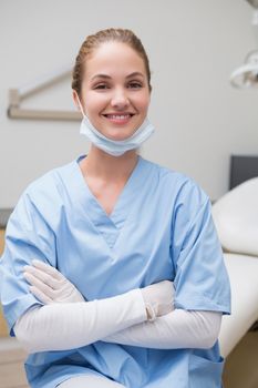 Dentist in blue scrubs smiling at camera at the dental clinic