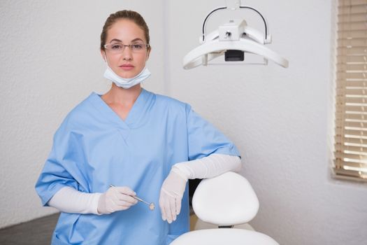 Dentist in blue scrubs looking at camera at the dental clinic