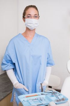 Dentist in blue scrubs looking at camera in mask at the dental clinic