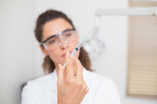 Dental assistant preparing an injection at the dental clinic