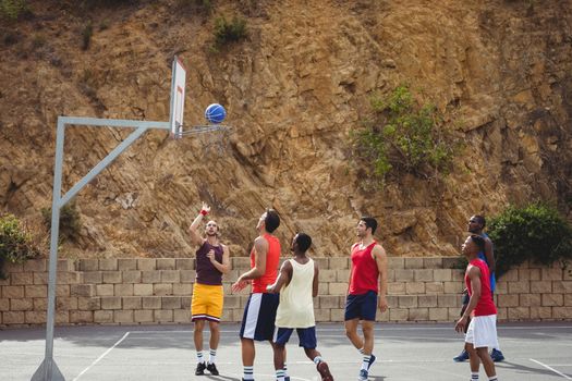 Basketball players playing basketball in the court outdoors