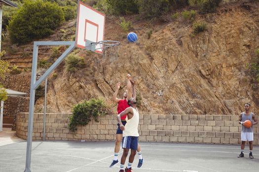 Basketball players playing practicing in basketball court outdoors