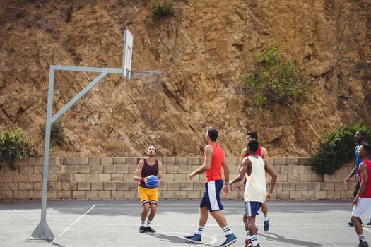 Basketball players playing basketball in the court outdoors