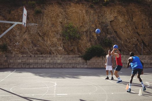 Basketball player taking a penalty shot in basketball court outdoors