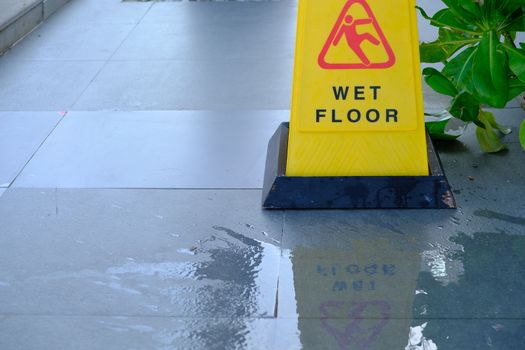 Close up of Warning Caution at outdoor walkway. Yellow sign showing warning of caution wet floor Conceptual image.