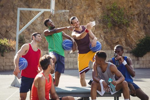 Basketball players taking a selfie in basketball court outdoors