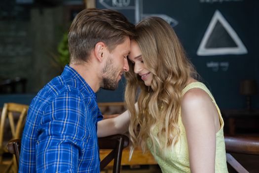 Close up of romantic couple with eyes closed standing in cafe shop 
