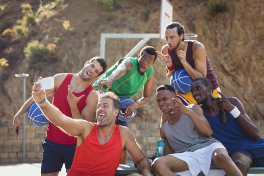 Basketball players taking a selfie in basketball court outdoors